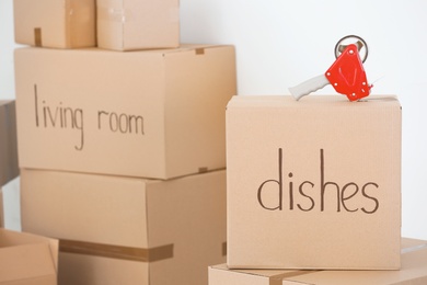 Photo of Moving boxes and adhesive tape dispenser on light background