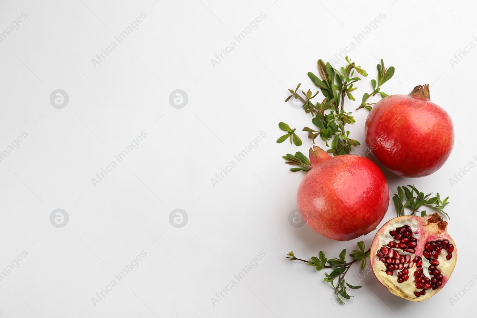 Photo of Flat lay composition with ripe pomegranates on white background. Space for text