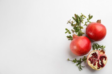 Flat lay composition with ripe pomegranates on white background. Space for text