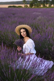 Photo of Beautiful young woman sitting in lavender field