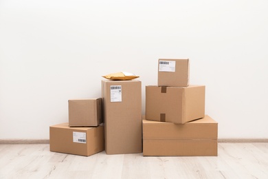 Stacked parcel boxes on floor against light wall