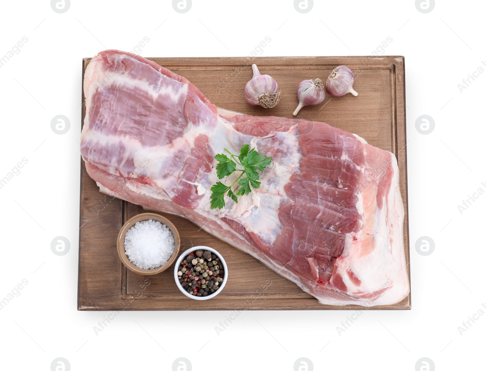 Photo of Piece of raw pork belly, parsley, garlic and spices isolated on white, top view