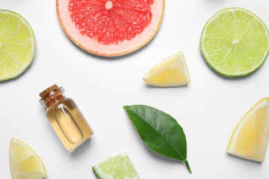 Flat lay composition with bottle of citrus essential oil on white background