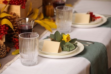 Beautiful autumn place setting with blank cards and decor on table