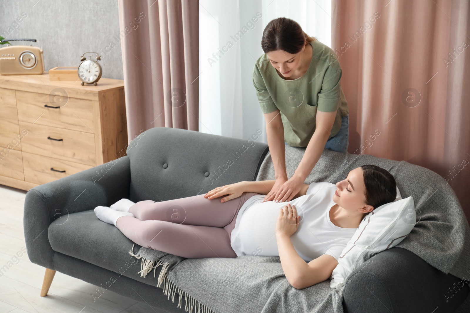 Photo of Doula taking care of pregnant woman at home. Preparation for child birth