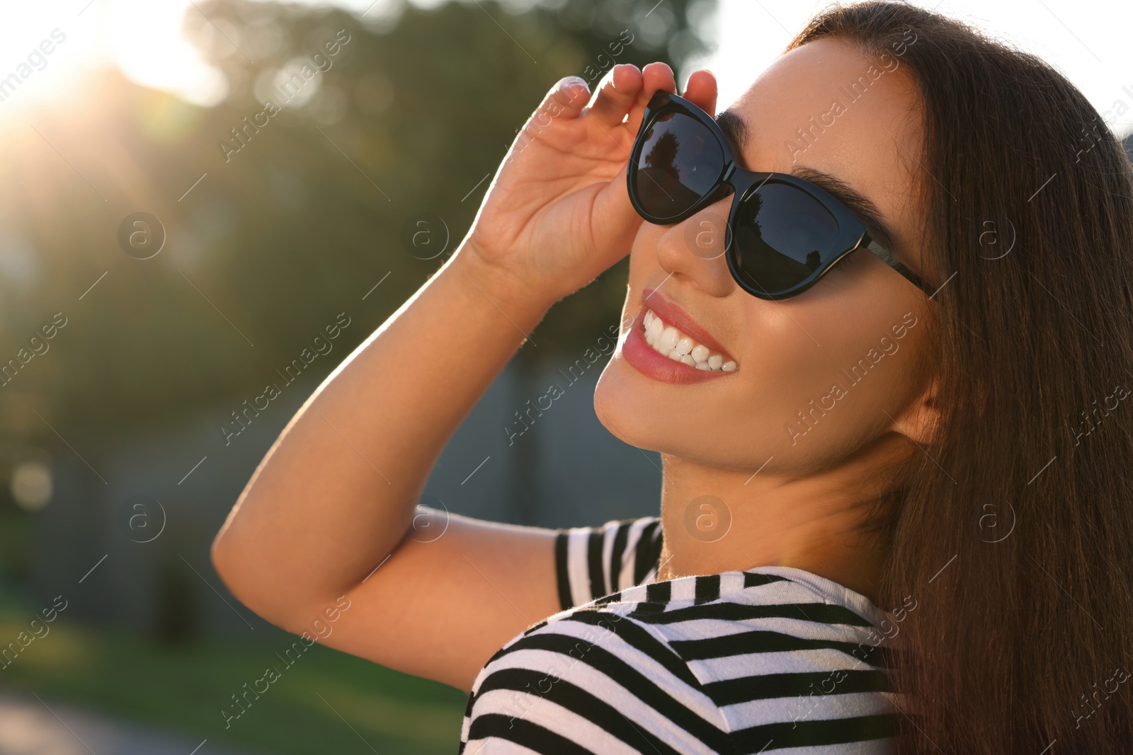 Photo of Beautiful smiling woman in sunglasses outdoors, space for text