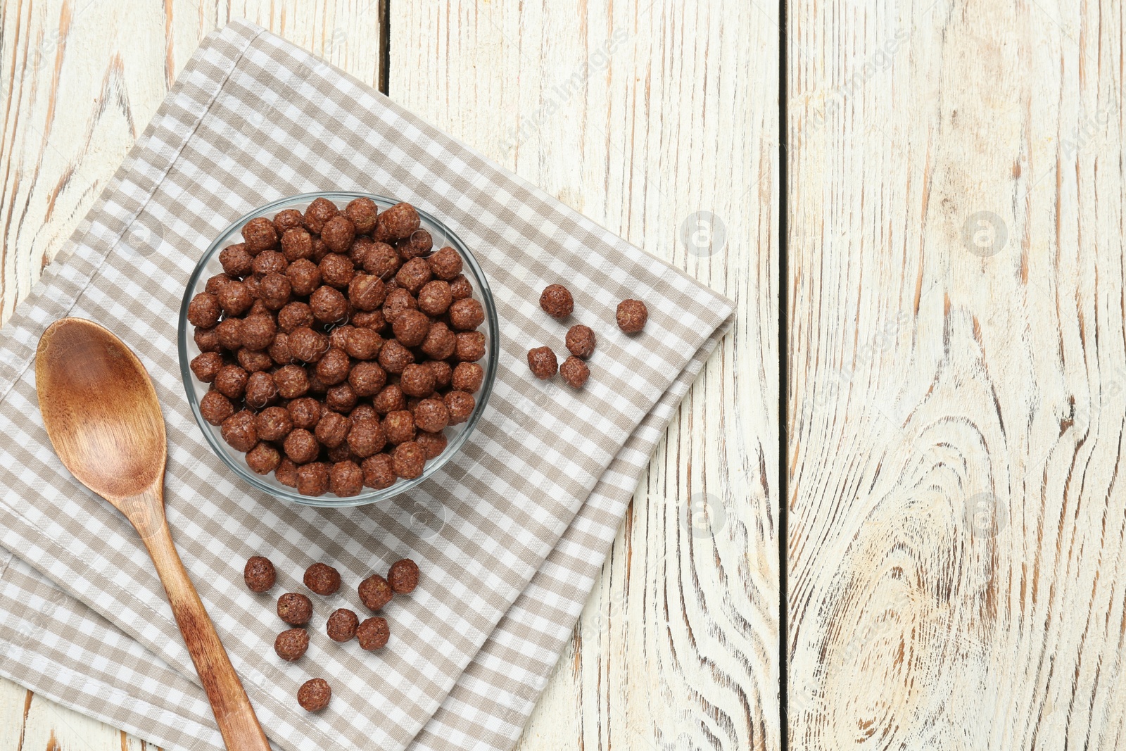 Photo of Tasty corn balls and spoon on white wooden table, top view with space for text. Healthy breakfast cereal