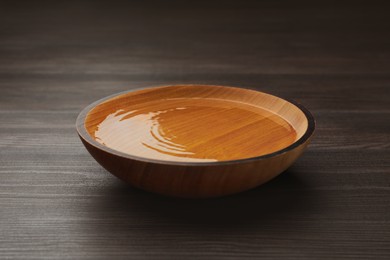 Photo of Bowl with clear water on dark wooden table
