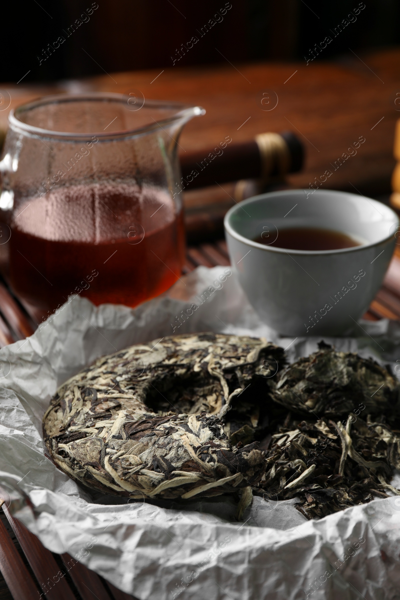 Photo of Broken disc shaped pu-erh tea on wooden tray, closeup. Traditional ceremony