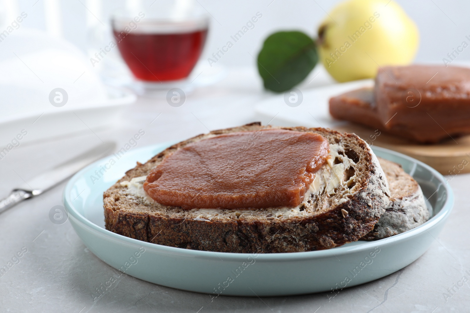 Photo of Tasty sandwich with quince paste served for breakfast on light table, closeup