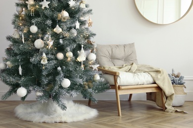 Photo of Beautiful decorated Christmas tree with skirt in room