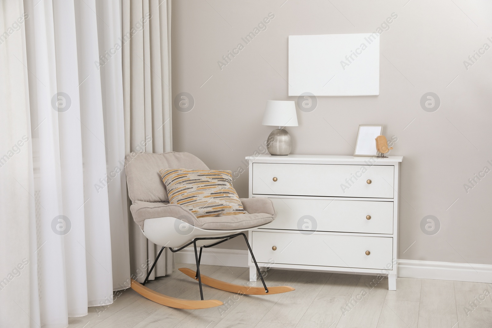 Photo of Blank canvas on wall over chest of drawers with decor in room. Space for design