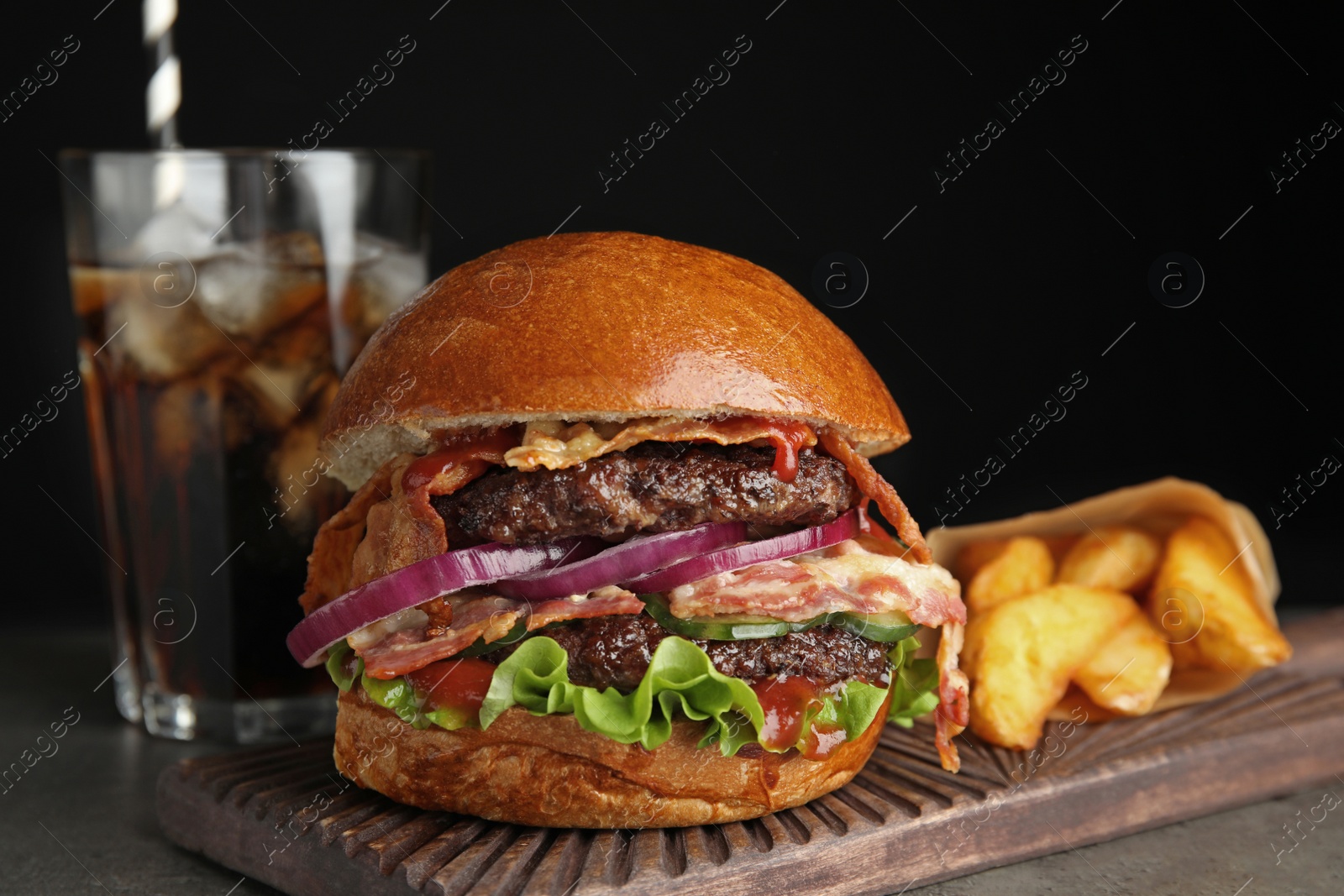 Photo of Tasty burger with bacon and fried potatoes served on table