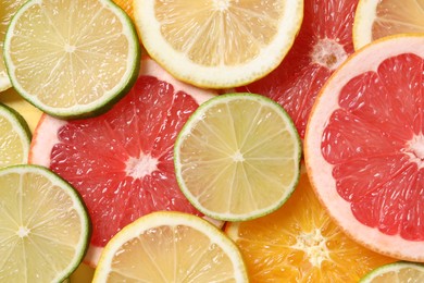 Photo of Different sliced citrus fruits as background, top view