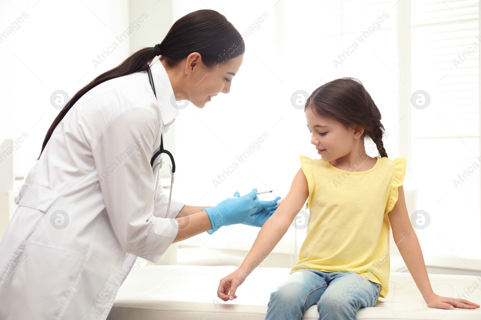 Photo of Doctor vaccinating little child in modern clinic