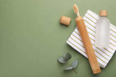 Flat lay composition with bamboo toothbrush on green background, space for text