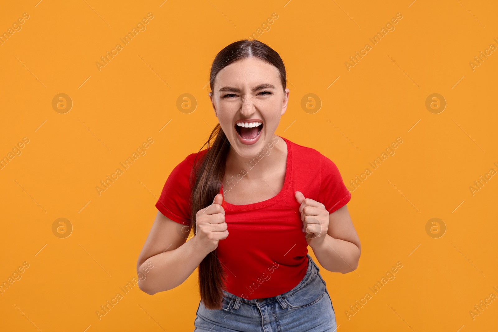 Photo of Emotional sports fan celebrating on orange background