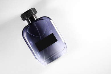 Luxury men`s perfume in bottle on white background, top view. Space for text