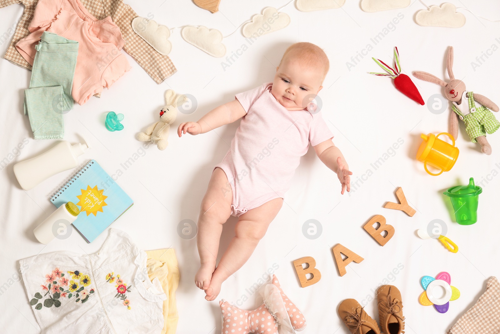 Photo of Cute little baby with clothing and accessories on white background, top view