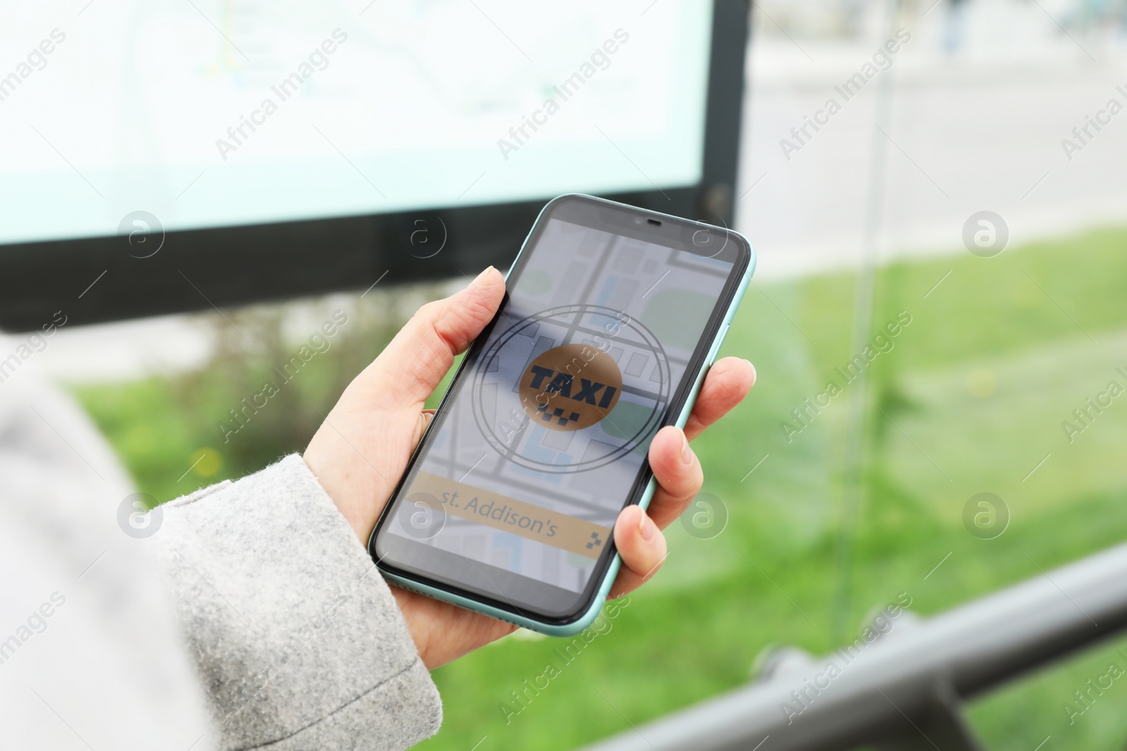 Photo of Woman ordering taxi with app on her smartphone outdoors, closeup