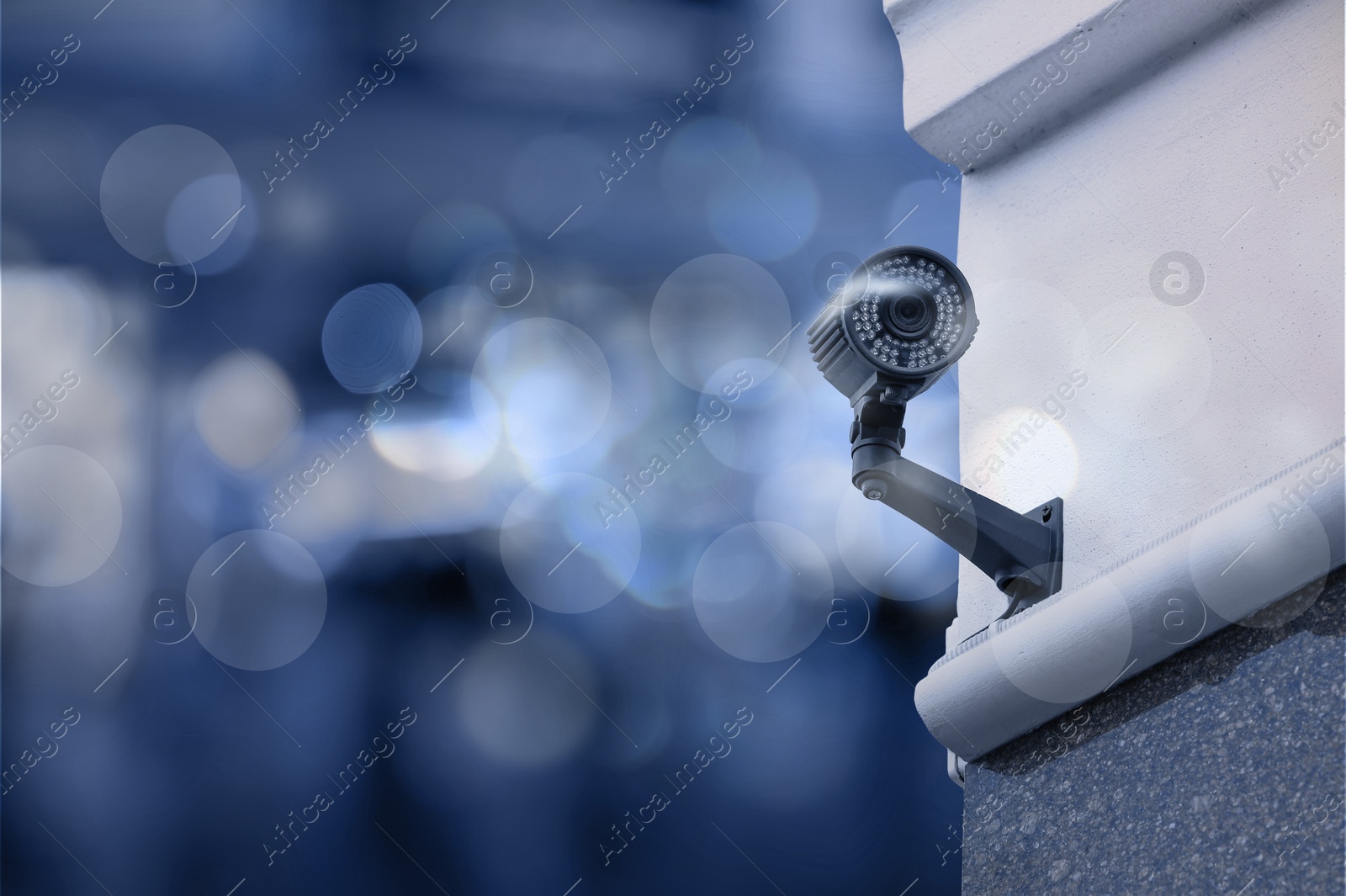 Image of Modern security CCTV camera on building wall outdoors, space for text