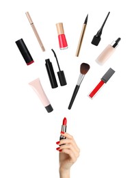 Woman holding red lipstick as magic wand making other decorative cosmetics flying on white background, closeup