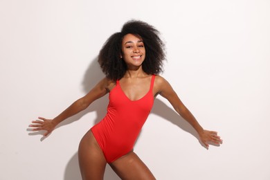 Beautiful woman in red one-piece summer swimsuit on white background