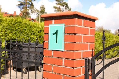 Photo of Number 1 on red brick column near house outdoors