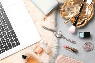 Photo of Set of accessories, cosmetics and laptop on grey background, flat lay. Beauty blogging