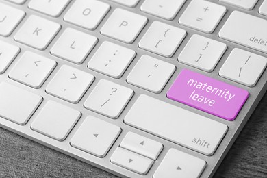 Image of Modern computer keyboard with text MATERNITY LEAVE on table, closeup