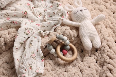 Photo of Baby accessories. Toys and cloth on knitted fabric