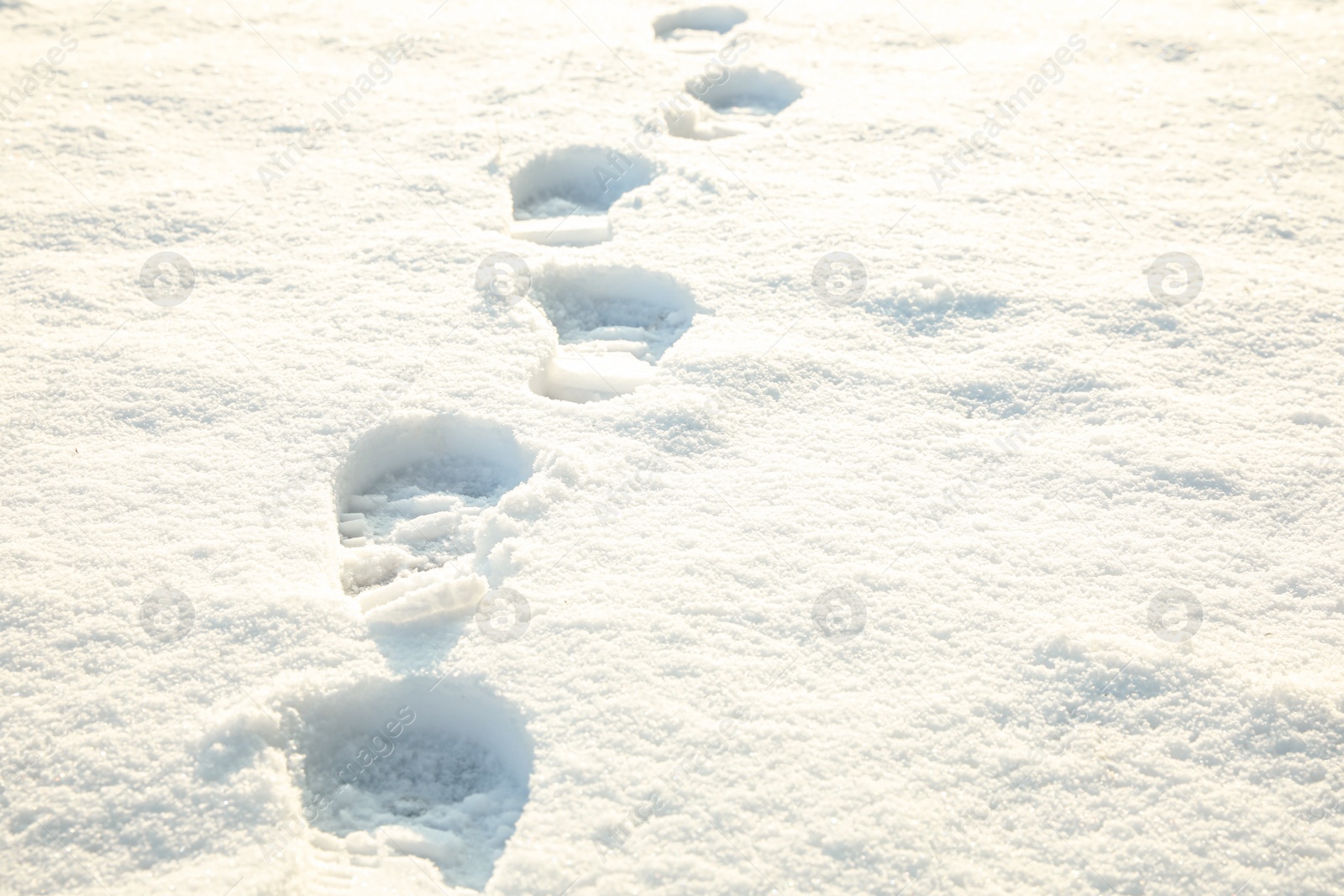 Photo of Footprints on white snow outdoors. Winter season