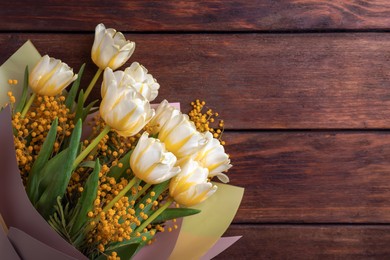 Bouquet with beautiful tulips and mimosa flowers on wooden table, top view. Space for text