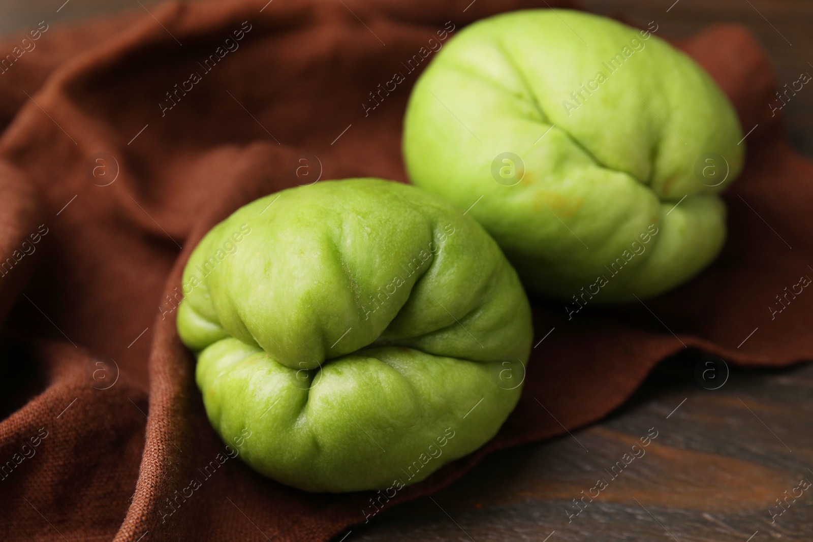 Photo of Fresh green chayote on wooden table, closeup