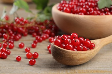 Many ripe red currants on wooden table