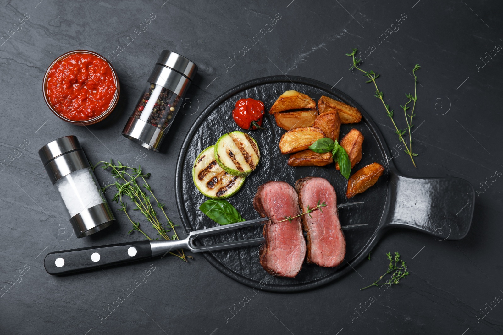 Photo of Flat lay composition with slices of grilled meat on black table