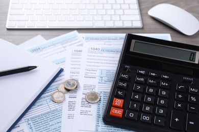 Tax accounting. Calculator, documents, coins, keyboard and stationery on table, closeup