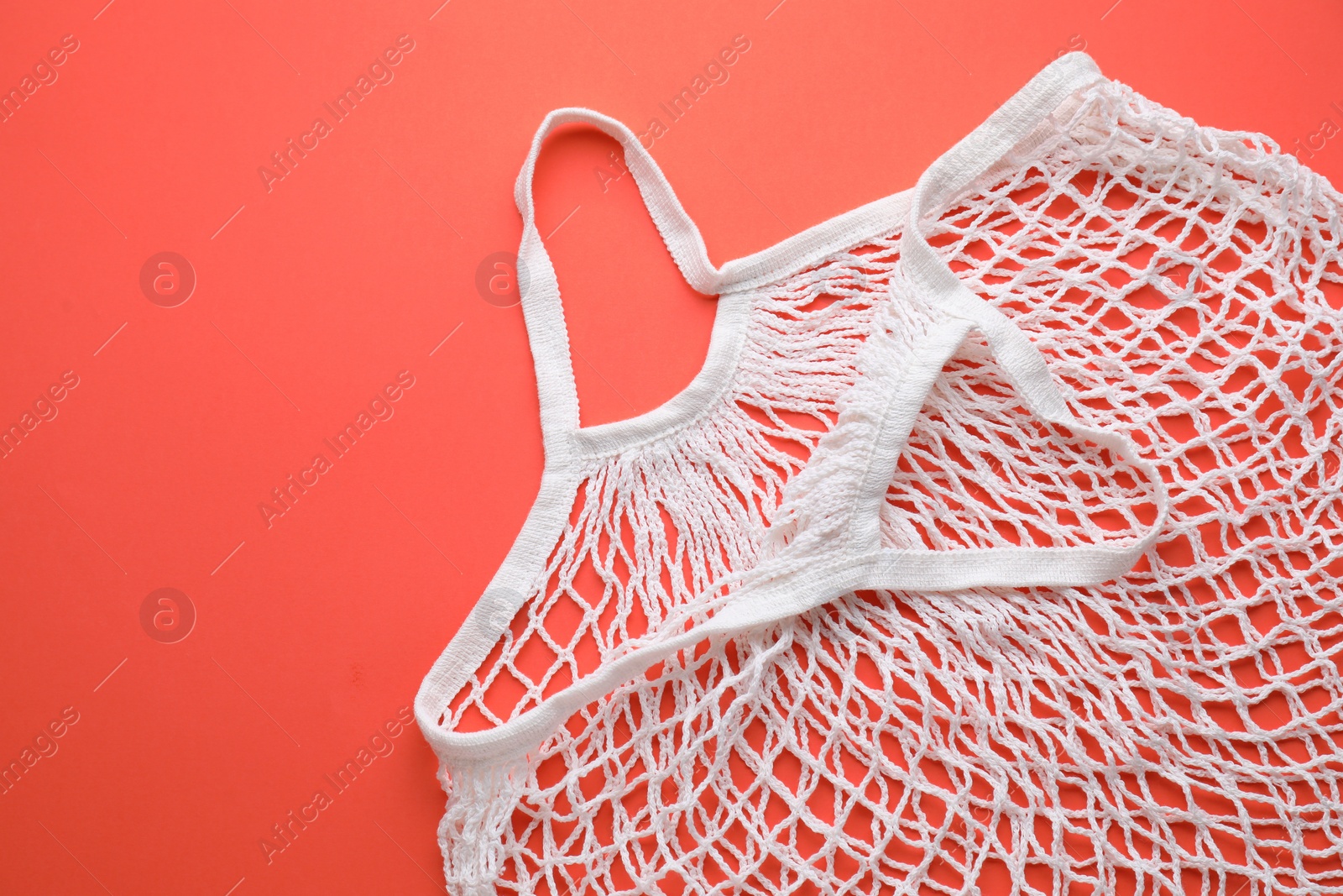 Photo of White string bag on red background, top view. Space for text