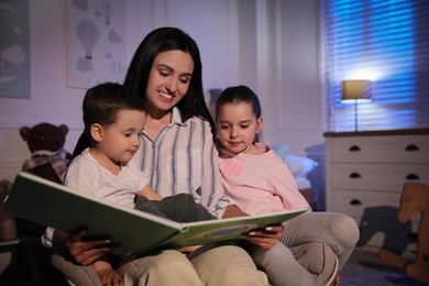 Mother reading bedtime story to her children at home