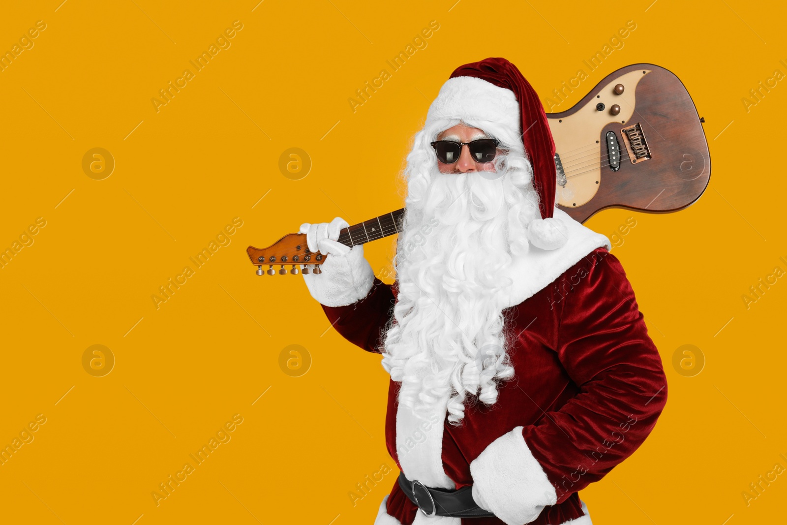 Photo of Santa Claus with electric guitar on yellow background, space for text. Christmas music