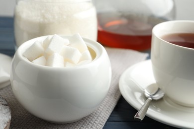 Photo of Refined sugar cubes in ceramic bowl on table