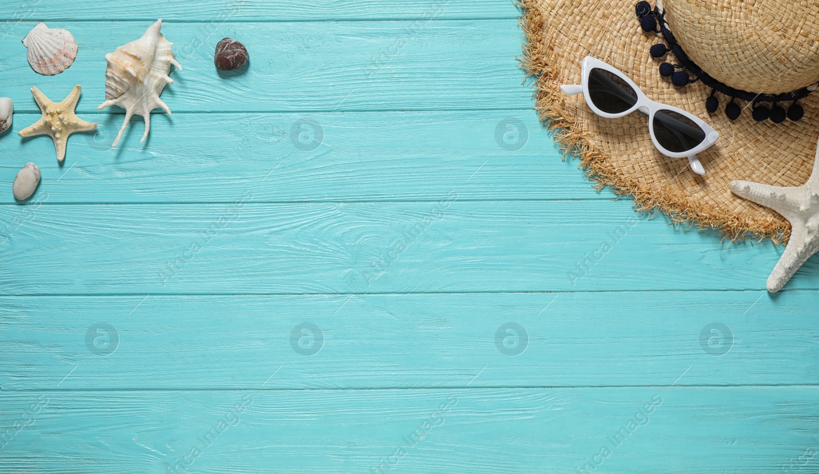 Photo of Flat lay composition with stylish beach accessories on light blue wooden background, space for text