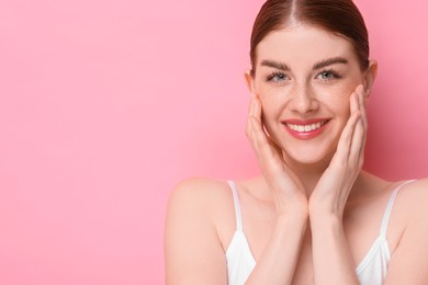 Photo of Portrait of smiling woman on pink background. Space for text