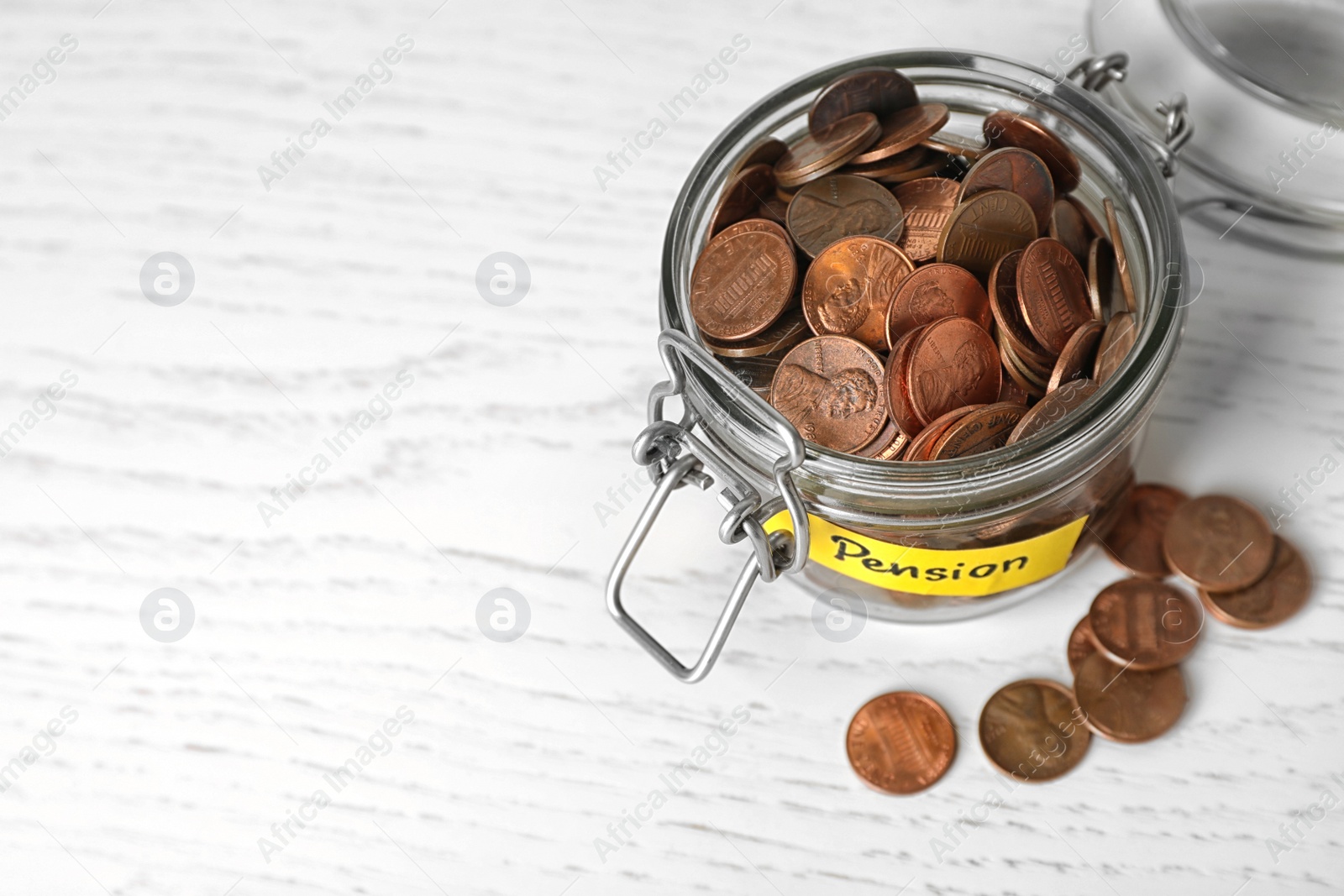 Photo of Coins in glass jar with label "PENSION" on light table. Space for text