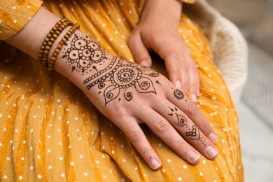 Photo of Woman with beautiful henna tattoo on hand, closeup. Traditional mehndi