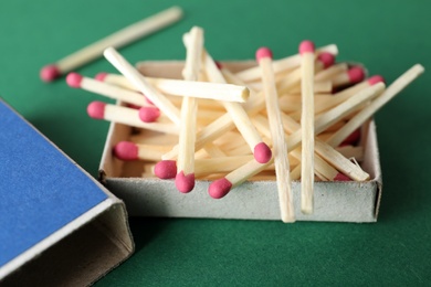 Photo of Open box with matches on color background, closeup