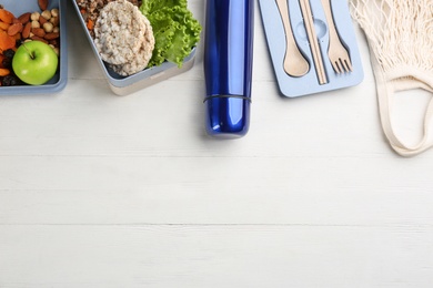 Flat lay composition with thermos on white wooden background, space for text