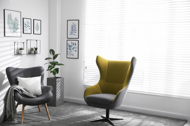 Comfortable armchairs near window in light room