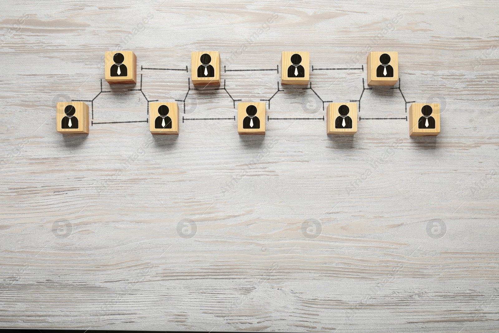 Image of Teamwork. Cubes with human icons linked together symbolizing cooperation on white wooden background, top view. Space for text