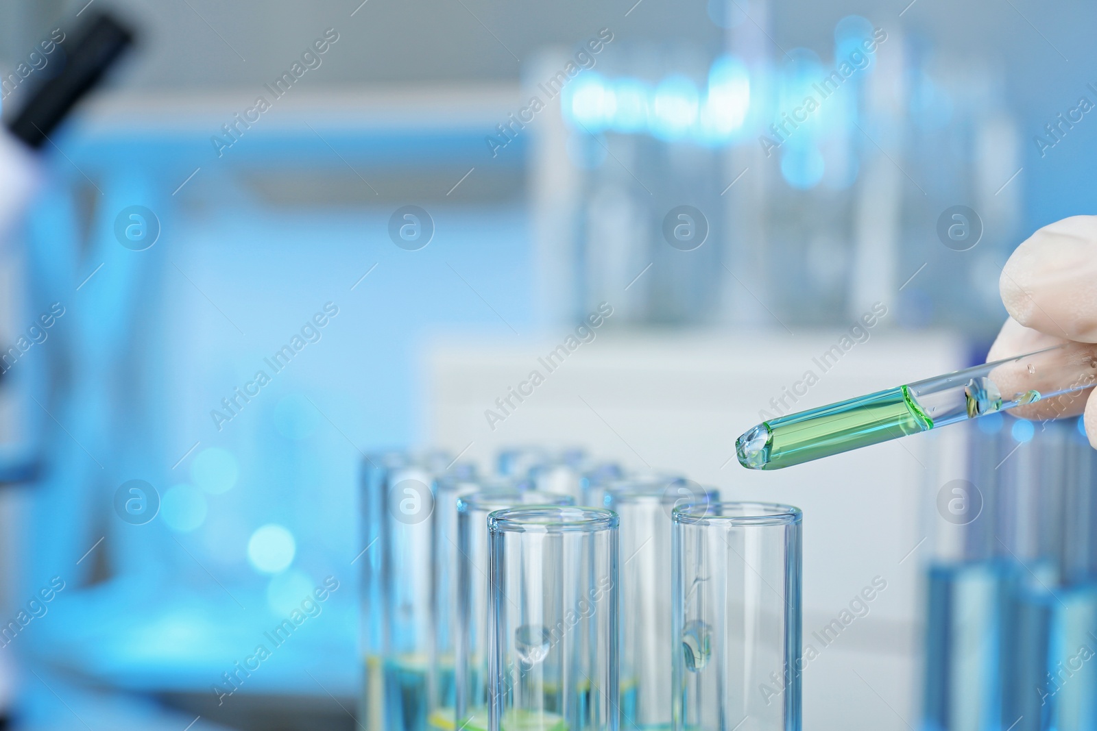 Photo of Analyst dripping reagent into test tube with sample at laboratory, closeup. Chemical analysis